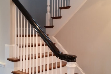 ボストンにある中くらいなトラディショナルスタイルのおしゃれな折り返し階段 (フローリングの蹴込み板、木材の手すり) の写真