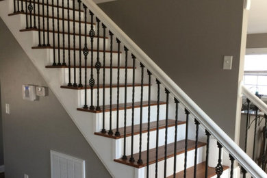 Imagen de escalera recta clásica de tamaño medio con escalones de madera, contrahuellas de madera pintada y barandilla de metal