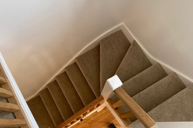 Inspiration för mellanstora moderna svängda trappor, med heltäckningsmatta, sättsteg med heltäckningsmatta och räcke i trä
