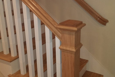 Imagen de escalera recta contemporánea de tamaño medio con escalones de madera, contrahuellas de madera pintada y barandilla de madera
