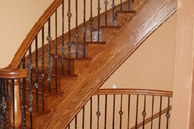 Imagen de escalera de caracol grande con escalones de madera y contrahuellas de madera