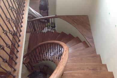 Example of a wooden curved staircase design in Toronto with wooden risers