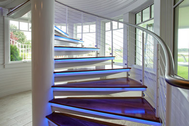 Cette photo montre un escalier sans contremarche hélicoïdal tendance de taille moyenne avec des marches en bois et un garde-corps en métal.