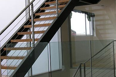 Cette image montre un grand escalier sans contremarche design en L avec des marches en bois.