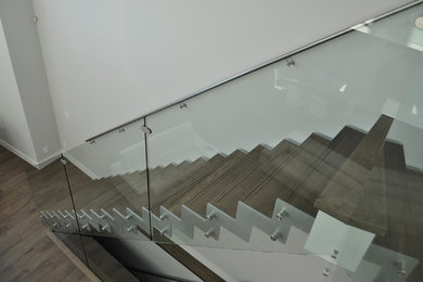 Ejemplo de escalera recta minimalista de tamaño medio sin contrahuella con escalones de madera