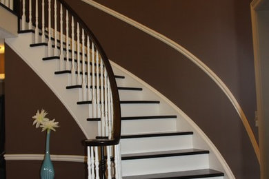 Ejemplo de escalera curva tradicional de tamaño medio con escalones de madera y contrahuellas de madera pintada