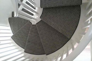 ニューヨークにあるトランジショナルスタイルのおしゃれならせん階段 (カーペット張りの蹴込み板) の写真