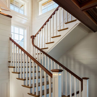 Example of a beach style wooden u-shaped wood railing staircase design in New York with painted risers