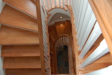 Modelo de escalera en U tradicional con escalones de madera, contrahuellas de madera pintada y barandilla de madera