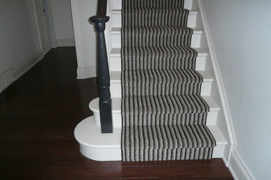 Modelo de escalera curva tradicional de tamaño medio con escalones de madera pintada y contrahuellas de madera pintada