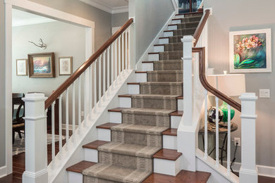 Elegant wooden u-shaped staircase photo in Miami with painted risers