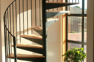 Imagen de escalera de caracol minimalista pequeña sin contrahuella con escalones de madera