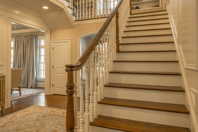 Medium sized classic wood l-shaped wood railing staircase in Other with painted wood risers.