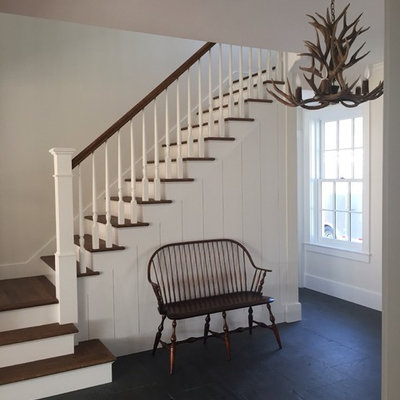 Example of a mid-sized country wooden straight staircase design in Burlington with painted risers