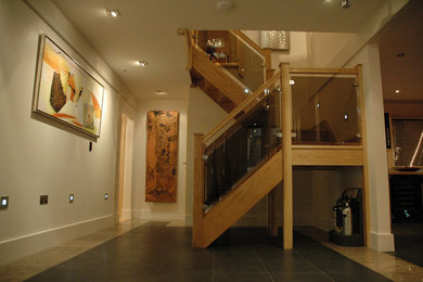 This is an example of a medium sized contemporary wood u-shaped staircase in Cambridgeshire with open risers.