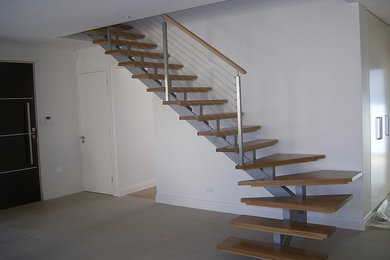Exemple d'un escalier tendance en L de taille moyenne avec des marches en bois.