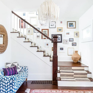 Imagen de escalera en L, ecléctica, de tamaño medio, con escalones de madera, contrahuellas de madera pintada y barandilla de madera