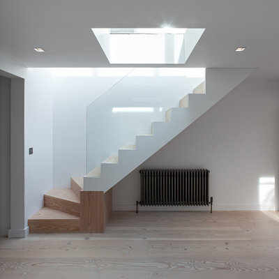 Mid-sized trendy wooden l-shaped staircase photo in London with wooden risers