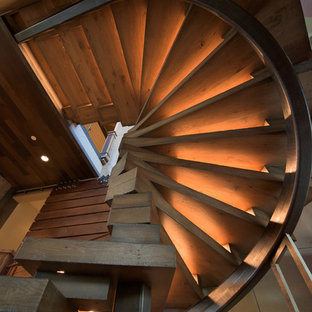 Foto di una grande scala curva industriale con pedata in legno e nessuna alzata