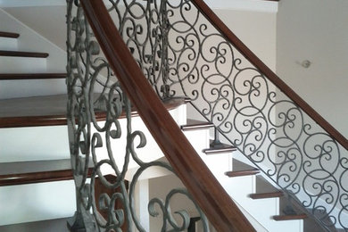 Photo of an expansive traditional wood curved staircase in Sacramento with painted wood risers.