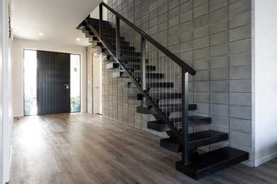 Ejemplo de escalera suspendida urbana de tamaño medio sin contrahuella con escalones de madera y barandilla de metal