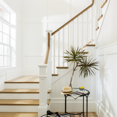 Example of a large beach style wooden l-shaped staircase design in Miami with painted risers