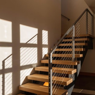 Foto di una scala a "L" minimal di medie dimensioni con pedata in legno, nessuna alzata e parapetto in cavi