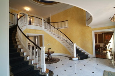 На фото: изогнутая лестница среднего размера в классическом стиле с ступенями с ковровым покрытием и ковровыми подступенками с