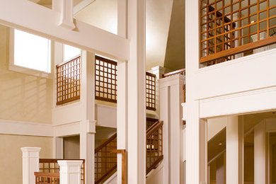 Diseño de escalera de estilo americano grande con escalones de madera, contrahuellas de madera pintada y barandilla de madera