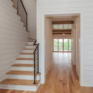 Immagine di una grande scala a "U" stile marinaro con pedata in legno, alzata in legno verniciato, parapetto in metallo e pareti in perlinato