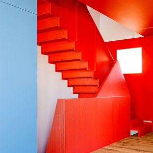Imagen de escalera en L, minimalista, pequeña, con escalones de metal, contrahuellas de metal y barandilla de metal