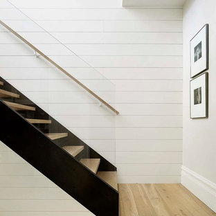 Exemple d'un escalier sans contremarche droit scandinave avec des marches en bois et un garde-corps en verre.