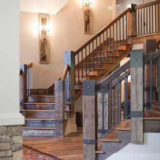 Ispirazione per una grande scala curva stile rurale con pedata in legno, alzata in legno e parapetto in legno
