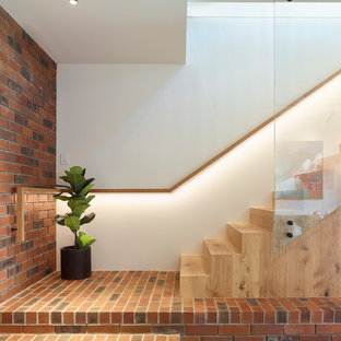 Contemporary wood straight staircase in Brisbane with wood risers and glass railing.