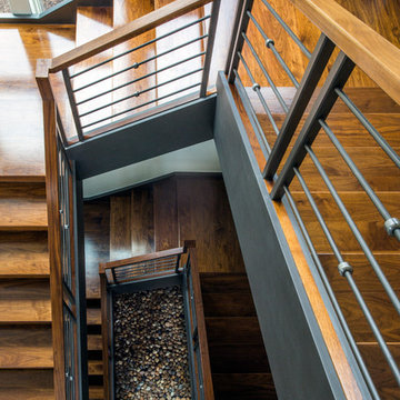 Three Story Floating Walnut Open Tread Staircase with Zen Garden at Base