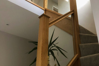 Bild på en mellanstor funkis u-trappa i trä, med räcke i glas