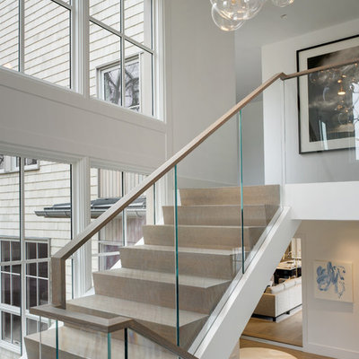 Inspiration for a contemporary wooden u-shaped glass railing staircase remodel in New York with wooden risers
