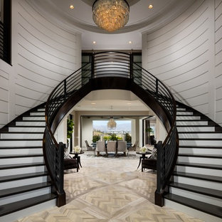 Diseño de escalera curva, tradicional renovada, con escalones de madera pintada y contrahuellas de madera pintada