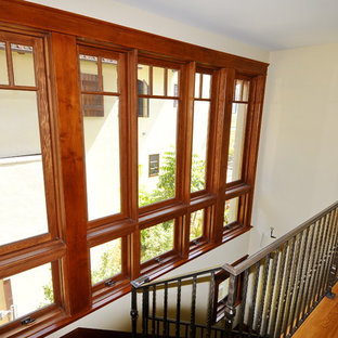 Immagine di una scala a "U" tropicale di medie dimensioni con pedata in legno, alzata in legno e parapetto in metallo