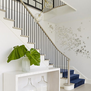 Staircase - coastal carpeted curved mixed material railing staircase idea in New York with carpeted risers
