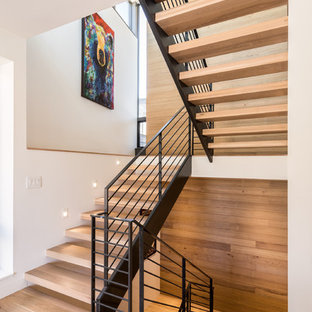 Modelo de escalera suspendida, actual, de tamaño medio, sin contrahuella, con escalones de madera y barandilla de cable