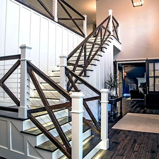 Immagine di un'ampia scala a "L" country con pedata in legno, parapetto in materiali misti e alzata in legno verniciato