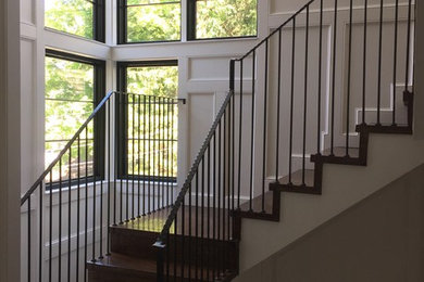 Large transitional wooden u-shaped metal railing staircase photo in New York with wooden risers