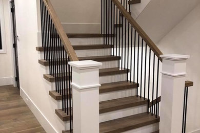 Imagen de escalera en U clásica renovada grande con escalones de madera, contrahuellas de madera pintada y barandilla de varios materiales