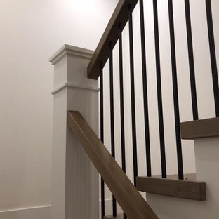 Idee per una grande scala a "U" classica con pedata in legno, alzata in legno verniciato e parapetto in materiali misti