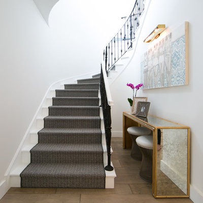 Transitional painted curved staircase photo in Orange County with painted risers