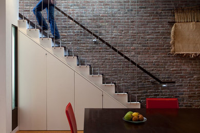 Réalisation d'un escalier design avec des marches en bois et rangements.