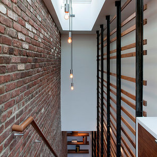 Large urban wooden straight open staircase photo in New York