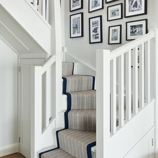 Gewendelte Maritime Treppe mit Teppich-Treppenstufen, Teppich-Setzstufen und Holzgeländer in Sonstige