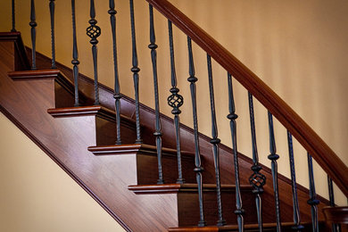Example of a large tuscan wooden curved staircase design in Detroit with wooden risers